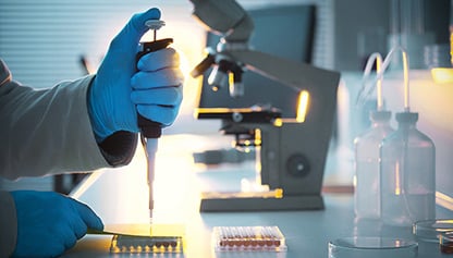 A scientist in a lab coat holds a test tube, conducting an experiment in a laboratory setting.